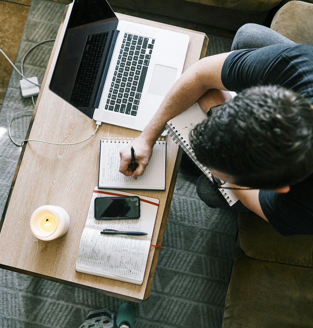 Man in black t-shirt sitting at the table using a laptop
